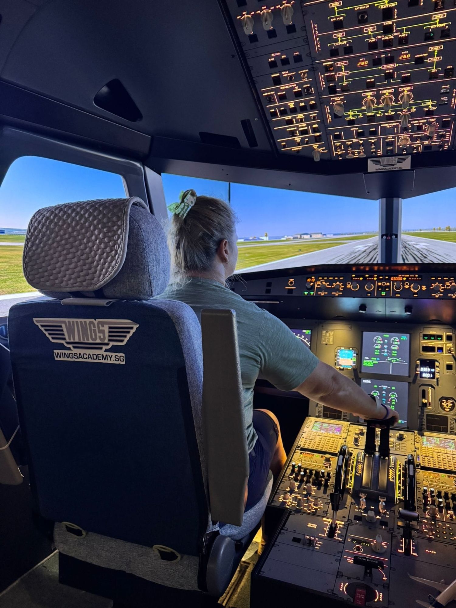 Natalia in the cockpit of a flight simulator at Wings Academy, Singapore