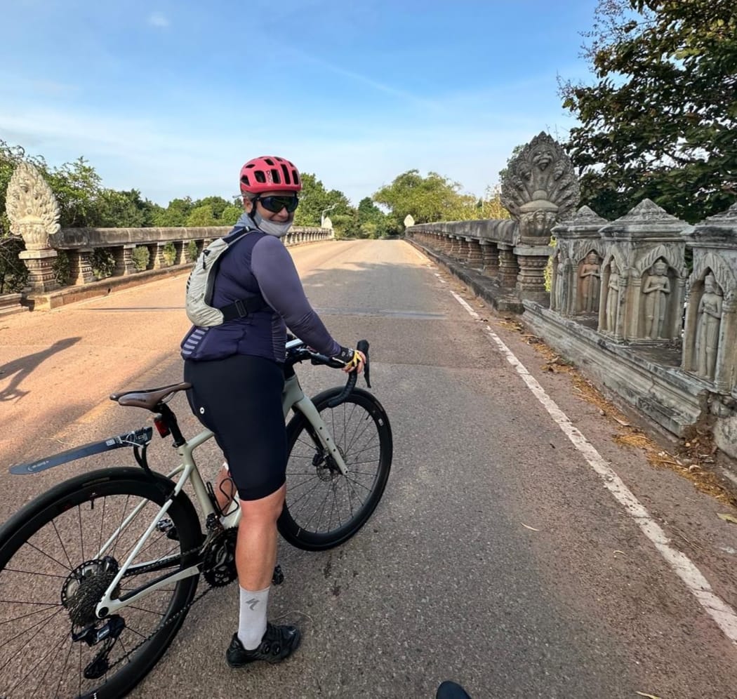 Cycling on an ancient Khmer bridge near Angkor Wat, Cambodia - HIRO4HOPE charity ride